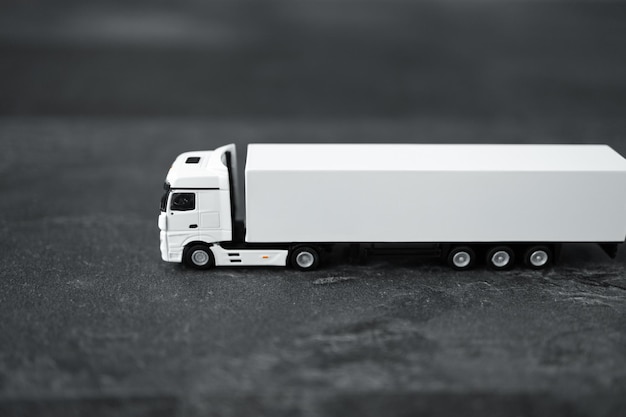 Miniature de camion long blanc avec une remorque sur fond sombre Chemin de détourage inclus