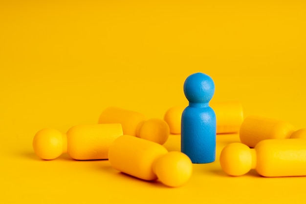 Photo miniatures humaines jaunes allongées sur une table et une bleue