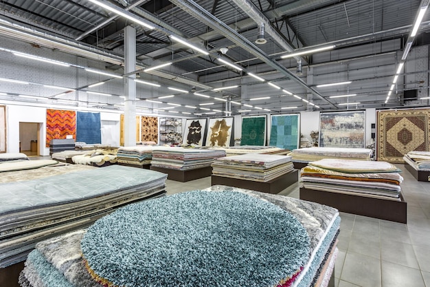 MINSK BÉLARUS SEPTEMBRE 2019 à l'intérieur de l'intérieur du magasin d'élite de tapis faits main tricotés à la machine des piles de tapis