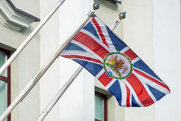 Photo minsk bélarus 20 février 2022 drapeau du royaume-uni de grande-bretagne avec les armoiries sur le bâtiment de l'ambassade en république du bélarus