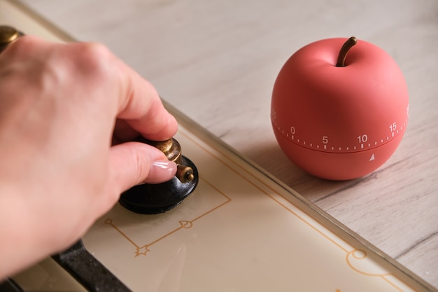 Minuterie de cuisine moderne en forme de pomme près de la plaque de cuisson dans la cuisine