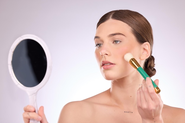 Miroir à main de maquillage ou femme avec une beauté au pinceau ou des cosmétiques pour le visage isolés sur fond de studio