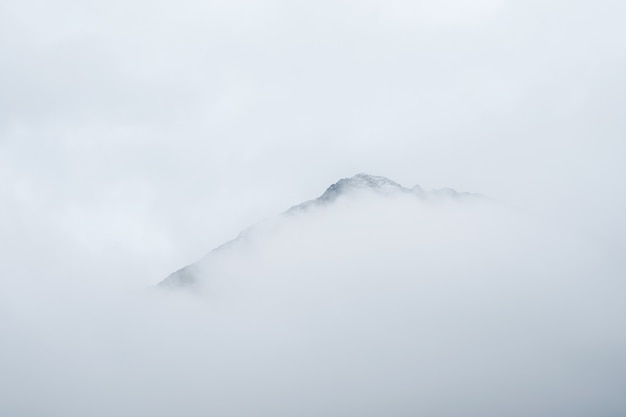 Mise au point douce. Paysage de montagne minimaliste. Magnifique paysage minimaliste avec de grands sommets enneigés au-dessus de nuages bas. Minimalisme atmosphérique avec de grands sommets enneigés dans un ciel nuageux.