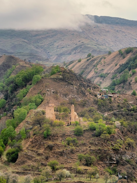 Mise au point douce. Sites du Daghestan. Ancien monastère en pierre sur la montagne verte. Complexe commémoratif Vatan, village de Sogratl au Daghestan. Russie. Vue verticale.