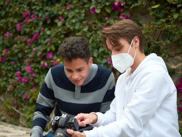 Une mise au point peu profonde de deux jeunes hommes regardant des photos à la caméra dans le parc