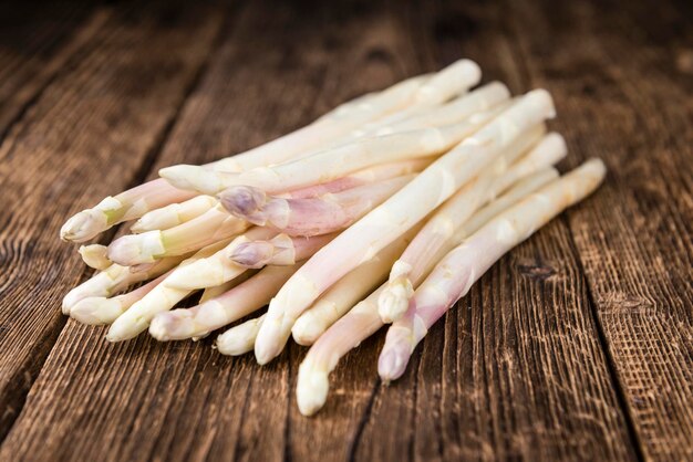 Mise au point sélective d'asperges blanches sur fond de bois