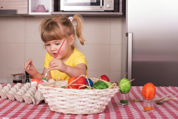 Mise au point sélective d'une belle petite fille peignant des œufs de Pâques