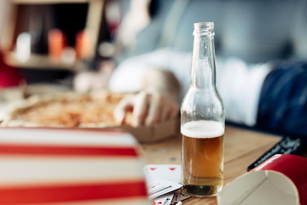 Mise au point sélective d'une bouteille de bière avec un homme en arrière-plan