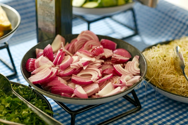 Mise au point sélective douce de l'oignon rouge hachant les légumes biologiques de la ferme sur une table de cuisson Nourriture saine végétarienne Une assiette avec des oignons rouges hachés pour la cuisson sur un plat Oignons rouges sur planche de bois