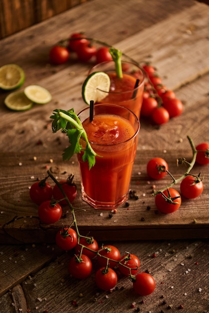 Mise au point sélective du cocktail Bloody Mary dans des verres sur fond de bois avec des tomates au poivre salé