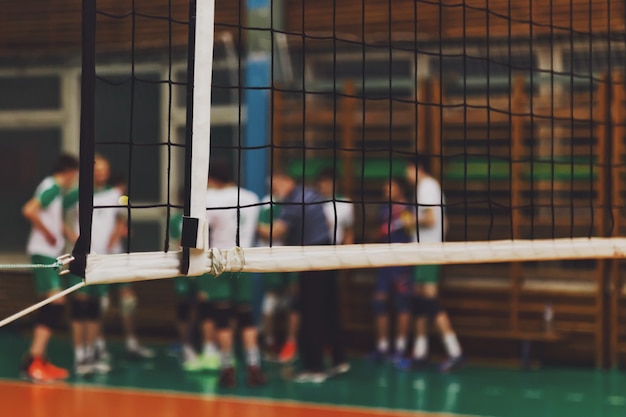 Mise au point sélective : l'entraîneur analyse le jeu de l'équipe de volley-ball pendant le temps mort dans la salle de sport. Contexte pour le jeu de volley-ball en équipe. Concept de sport, de mode de vie sain et de réussite en équipe. Espace de copie