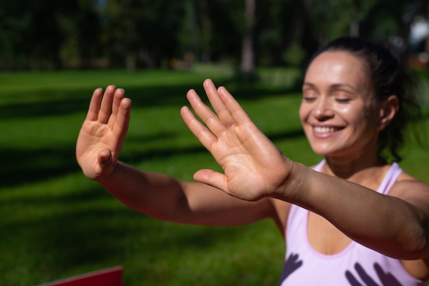 Mise au point sélective sur une femme souriante tout en prenant un bain de soleil et profiter d'une journée ensoleillée dans le parc