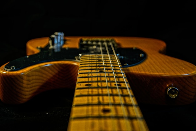 Mise au point sélective d'une guitare électrique marron isolée sur fond noir