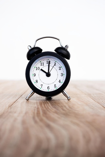 Mise au point sélective de l'horloge de table noire sur table en bois