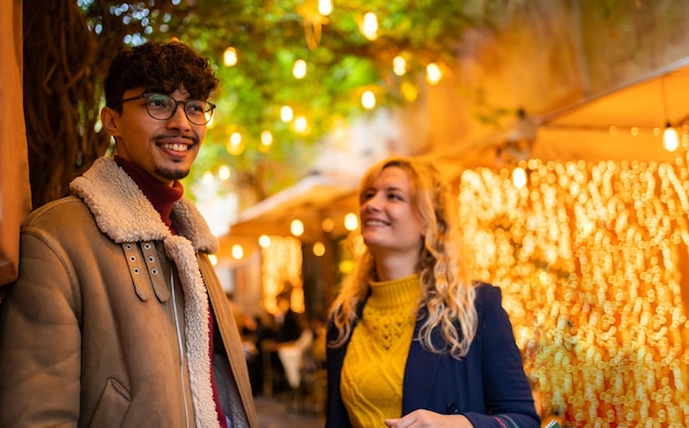 Mise au point sélective sur un jeune homme arabe souriant tout en parlant avec sa petite amie