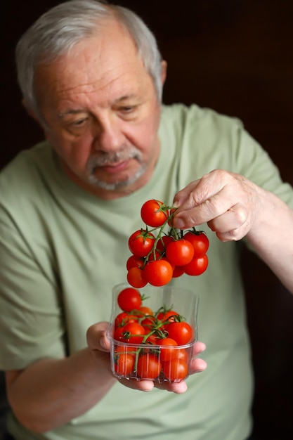 Mise au point sélective Macro Tomates cerises entre les mains d'un homme âgé Le concept d'une alimentation saine chez les personnes âgées