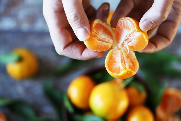 Mise au point sélective. mains mâles détiennent un mandarin divisé