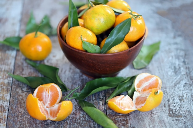 Mise au point sélective. Mandarines juteuses mûres dans un bol. Feuilles de mandarine. Mandarines fraîches parfumées. Récoltez les mandarines.