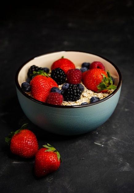 Mise Au Point Sélective, Nutrition Appropriée, Petit Déjeuner Sain, Assiette Creuse Avec Céréales, Flocons D'avoine, Fraises Fraîches, Framboises, Bleuets Et Mûres