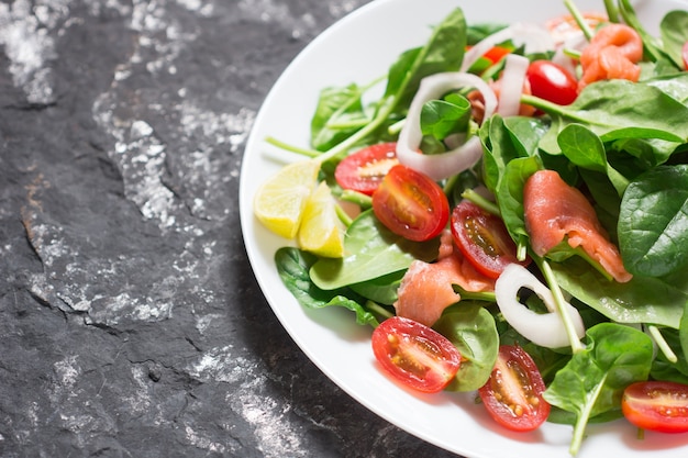 Mise au point sélective Saumon Vert frais Salade aux épinards, tomates cerises, bébés épinards