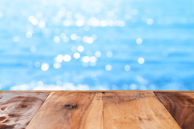 Mise au point sélective de la vieille table en bois avec un beau fond de plage pour afficher votre produit.