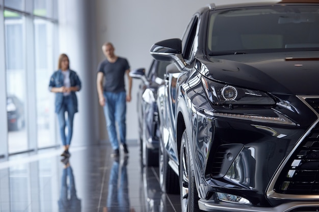 Mise au point sélective d'une voiture de luxe de luxe dans le contexte d'un couple marié choisissant une voiture