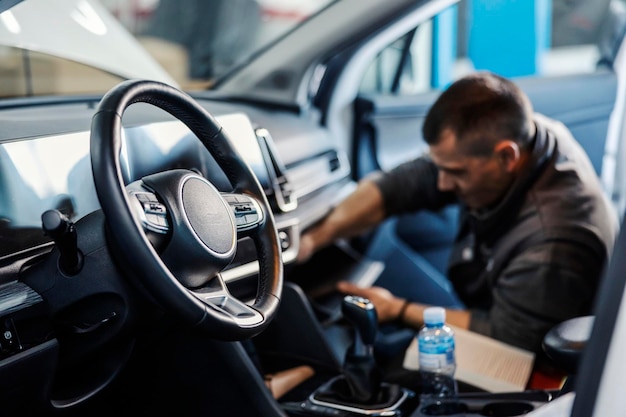 Mise au point sélective sur un volant avec changement de filtre à air mécanique dans la voiture à l'atelier de mécanique