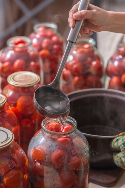 Mise en conserve de tomates mûres dans les boîtes