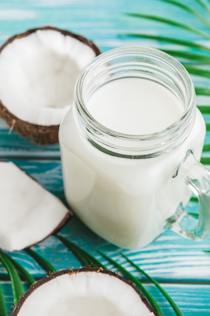 Mise en page créative faite de noix de coco et de feuilles tropicales. Aliments