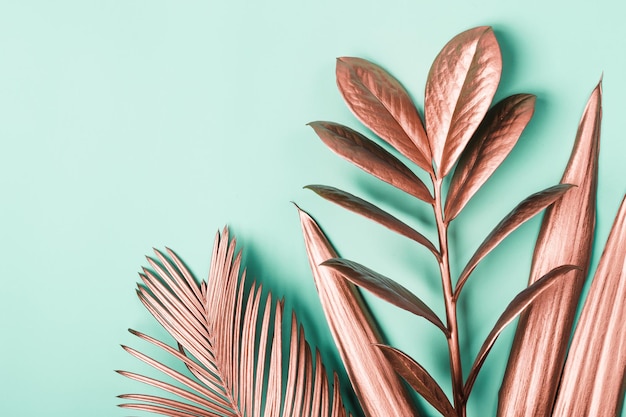 Mise en page créative naturelle faite de feuilles tropicales métalliques roses Fond de surréalisme minimal