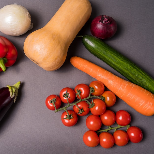 Mise en page avec différents légumes sur fond gris avec espace de copie.