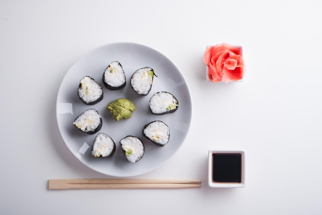 Mise en place de rouleaux de sushi végétariens d'avocat et de concombre avec wasabi au gingembre et sauce soja