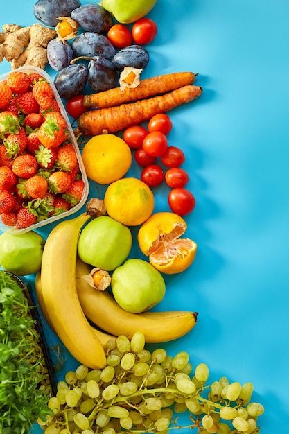 Mise à plat d'aliments sains biologiques mûrs Fruits micro-verts légumes sur fond bleu espace de copie pour le texte vue de dessus marché concept de ferme locale récolte de nourriture livraison régime végétalien concept