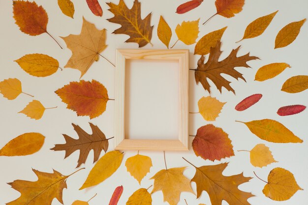 Mise à plat d'automne avec espace de copie. Beaucoup de feuilles d'automne et un cadre vide en bois