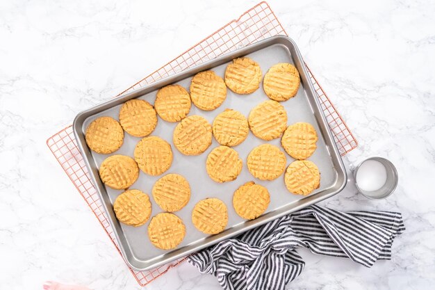 Mise à plat. Biscuits au beurre d'arachide fraîchement cuits sur une plaque à pâtisserie.