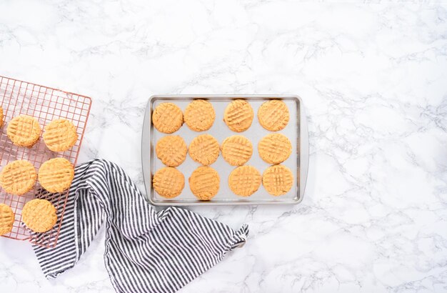 Mise à plat. Biscuits au beurre d'arachide fraîchement cuits sur une plaque à pâtisserie.