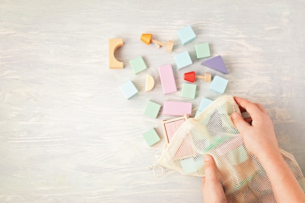 Mise à plat avec des blocs de bois aux couleurs pastel. Jouets écologiques, zéro déchet, sans plastique, éducatifs et neutres pour les enfants. Copier l'espace, vue de dessus