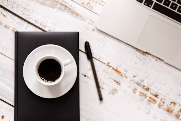 Mise à plat sur bois lavé avec tasse de café, ordinateur portable et téléphone portable