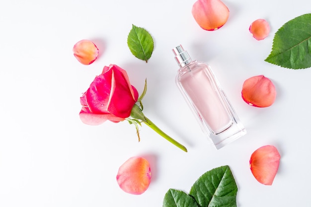 Mise à plat d'une bouteille de parfum féminin avec un parfum floral et des pétales de rose fond blanc vue de dessus une maquette vide de la bouteille