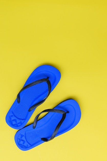 Mise à plat, chaussures de tongs de plage sur fond jaune, vue de dessus