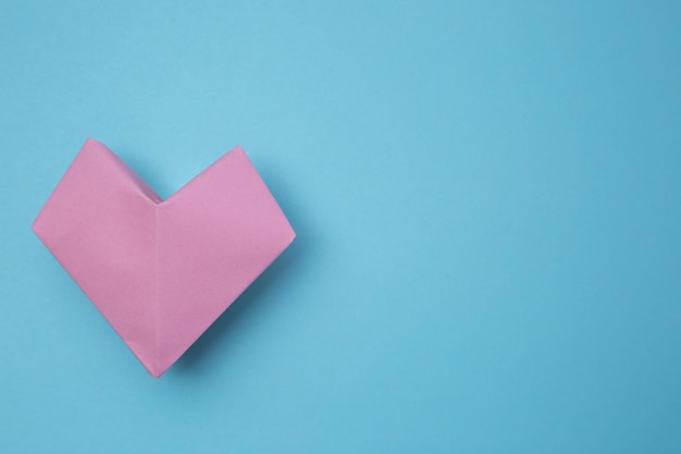 Mise à plat d'un cœur en origami rose sur la gauche. Bannière de site Web