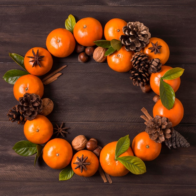 Photo mise à plat de la couronne de noël en mandarines et pommes de pin