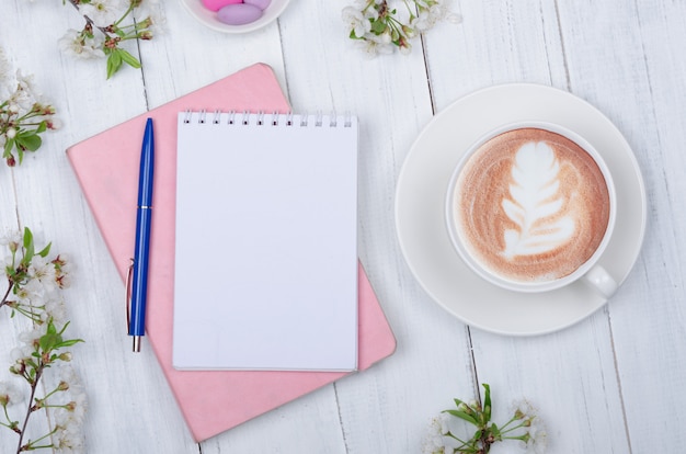 Mise à plat créative de bureau, bloc-notes et objets de style de vie sur fond de bois