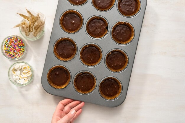 Mise à plat. Cuisson des cupcakes au chocolat dans un moule à cupcake.