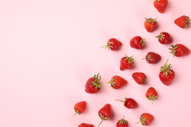 Mise à plat avec de délicieuses fraises sur fond rose