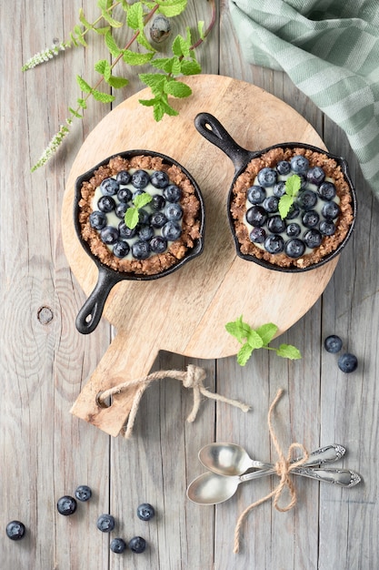 Mise à plat de délicieuses tartelettes aux bleuets avec crème à la vanille