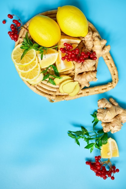 Mise à plat du remède de renforcement immunitaire stimulant l'immunité des aliments gingembre citron miel guelder rose menthe sur fond bleu vue de dessus copie spacexA