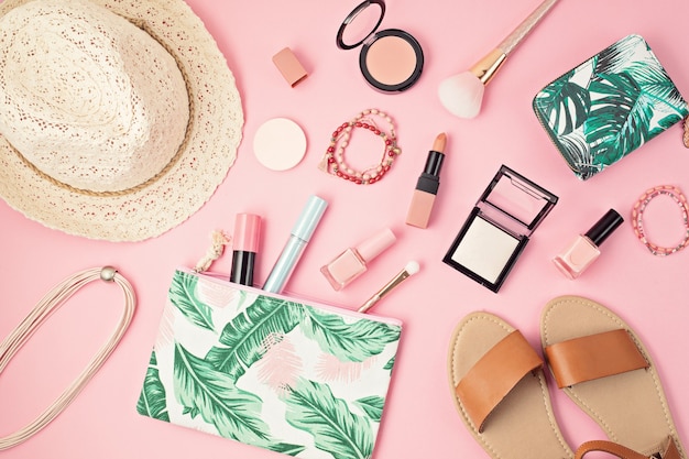 Mise à plat avec ensemble de cosmétiques décoratifs professionnels, outils de maquillage et printemps femme, accessoires d'été sur mur rose avec espace de copie. Blog de beauté, mode, fête, concept de magasinage. Vue de dessus