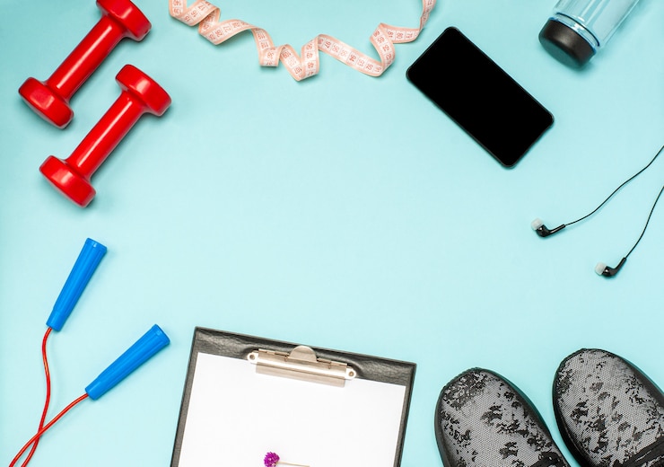 Photo mise à plat d'équipements sportifs pour le fitness sur une surface bleue