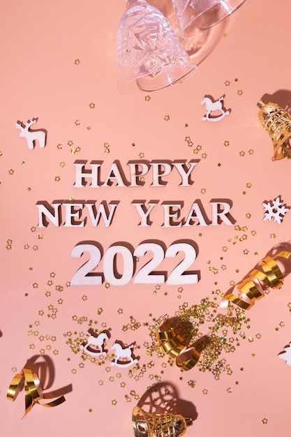 Mise à plat festive du nouvel an avec des numéros 2022 et des ombres dures avec des lunettes et un décor brillant